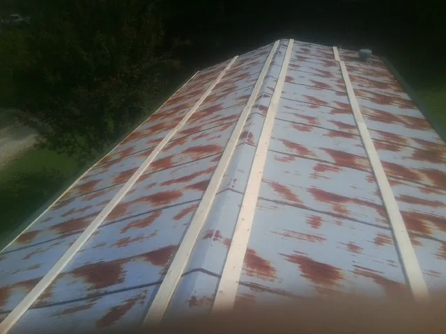 Rusted metal roof panels with new wood purlins before replacement — Storm Damage Roof Repair in Massillon by Roofing Brothers