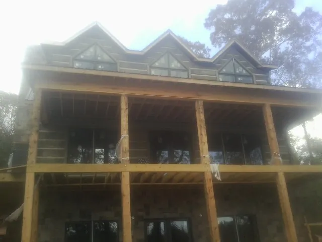 Dormers and porch framing on a large log home under construction — Roof Coating work by our crew in Massillon