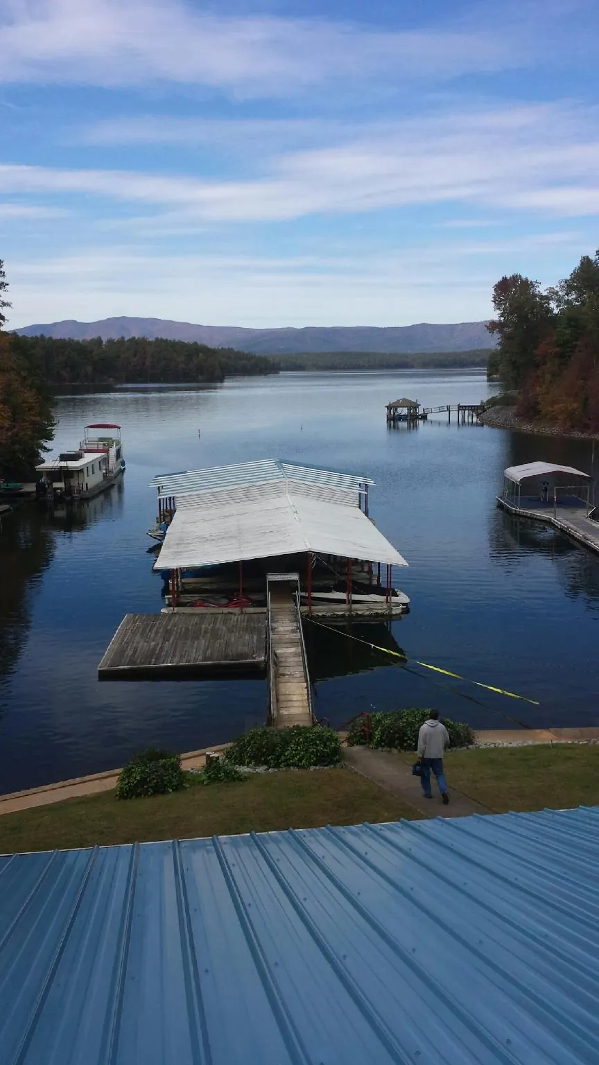 View across a lake from a newly installed blue metal roof in Massillon