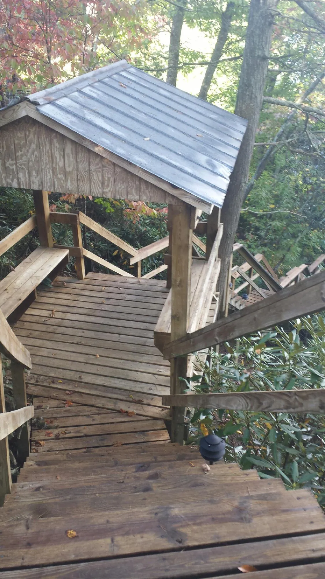 Metal roofed shelter over wooden steps on a wooded walkway — Skylight Repair & Installation work by our crew in Massillon
