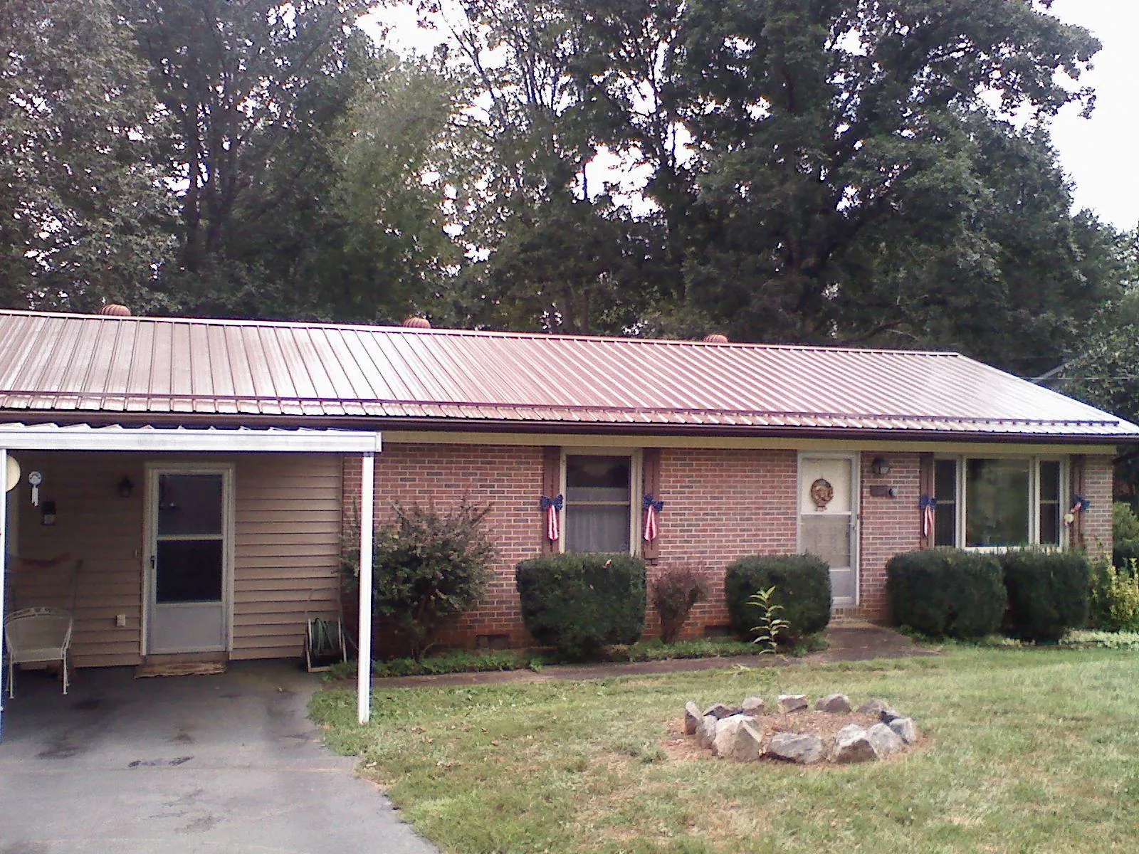 Bronze metal roof and carport on a brick ranch home — Roof Repair work by our crew in Massillon