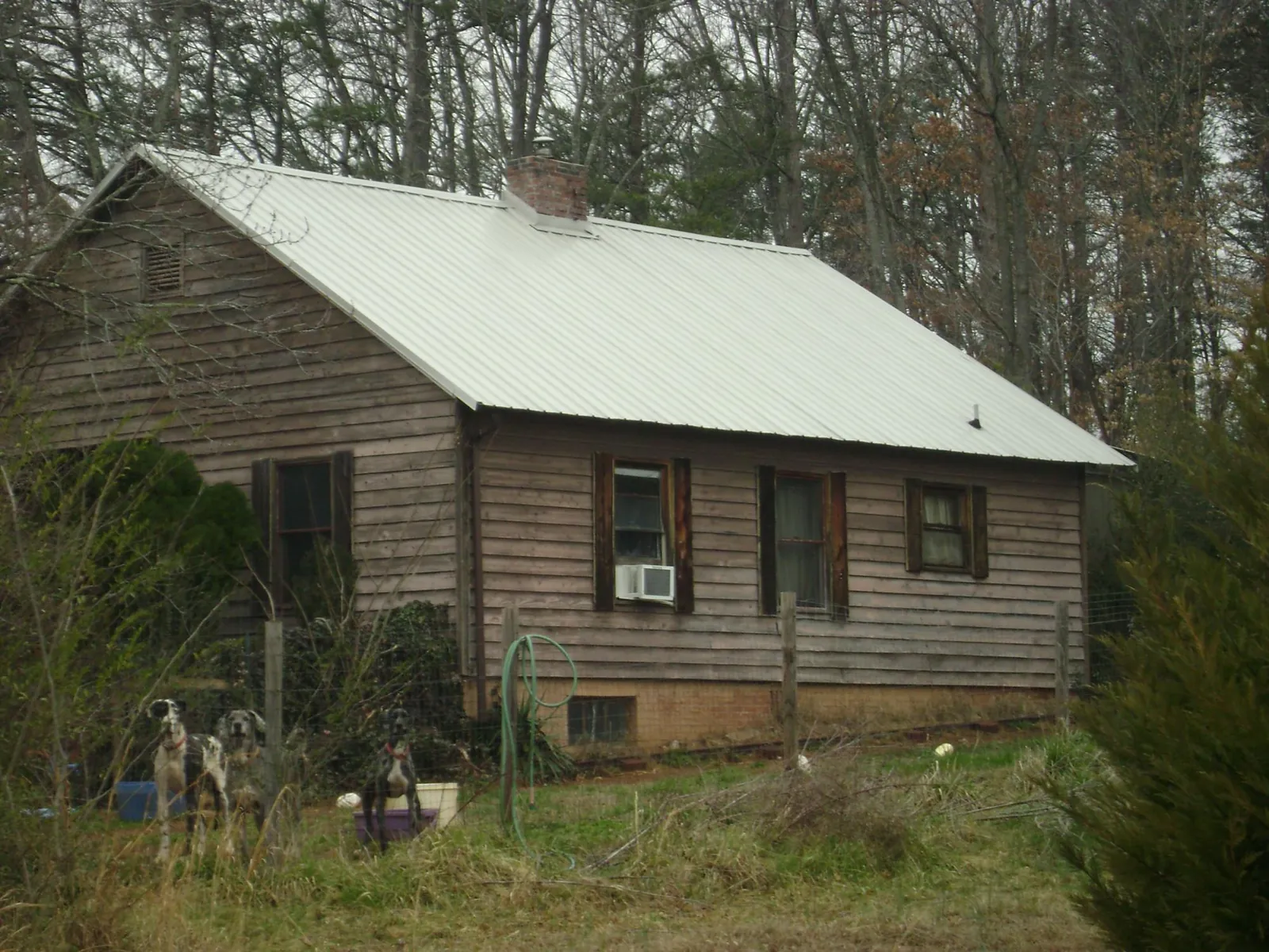 White metal roof on an old wood sided farmhouse, from a Asphalt Shingle Roof Repair job in Massillon